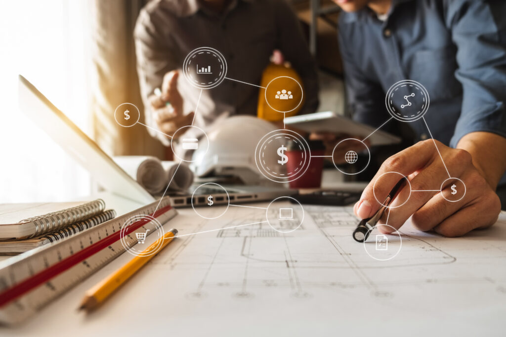 Two colleagues discussing data working and tablet, laptop with on on architectural project at construction site at desk in office